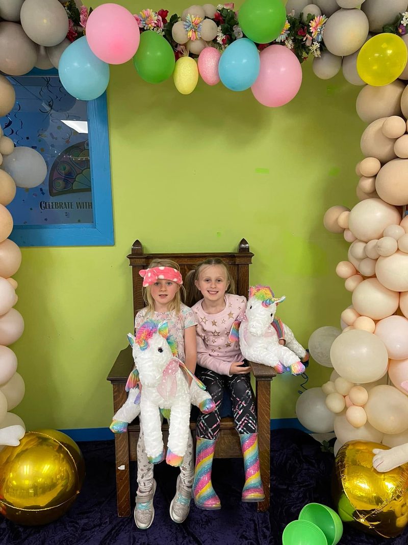 Child posing at a balloon arch at a Treasure Castle birthday party